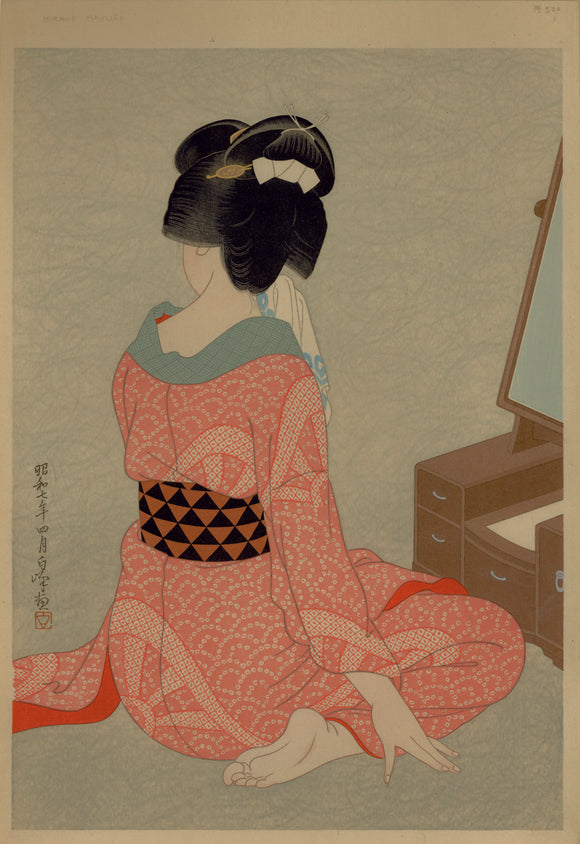 Hirano Hakuhō: “Woman Before A Mirror”. A seated beauty in a pink robe holds a towel to her face as she sits before a mirror.